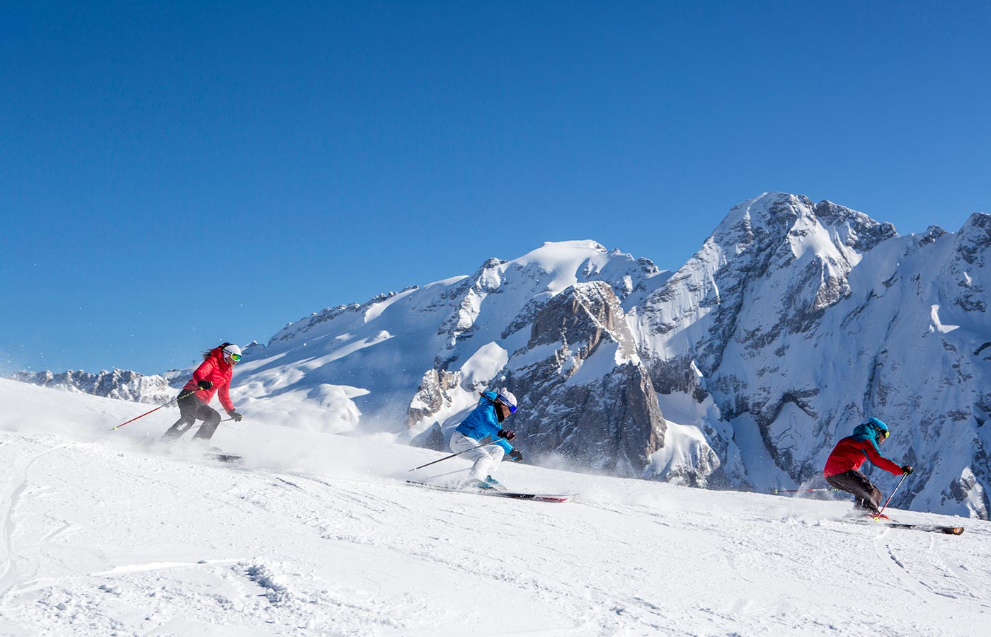 Three skiers start the descent from the mountain