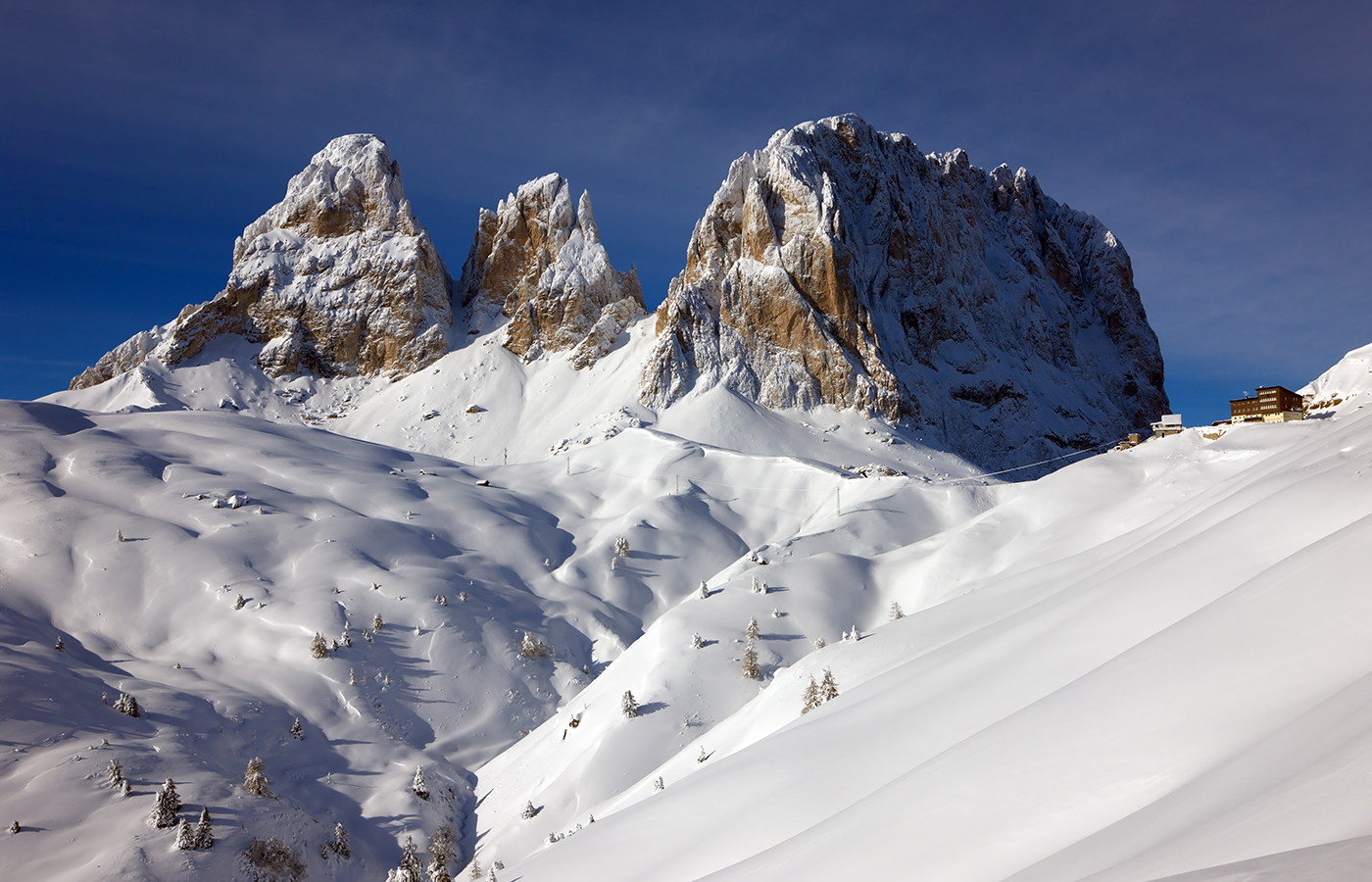 Falchi del Sassolungo in inverno con neve fresca e cielo terso