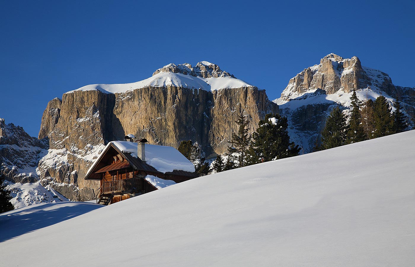 Typisches Holzhaus mit schneebedeckten Bergen im Hintergrund